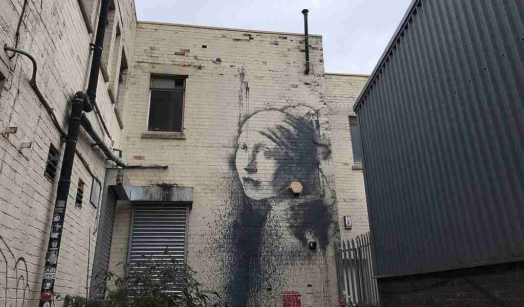 "Girl with a pierced eardrum", a work by Banksy parodying Johannes Vermeer's exchanging the jewel for an alarm.