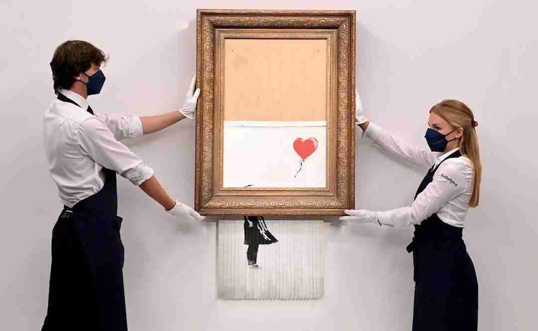 Love is in the bin, Banksy. Image of the painting Girl with Ball at the Moment of Self-Destruct at an auction at Sotheby's.