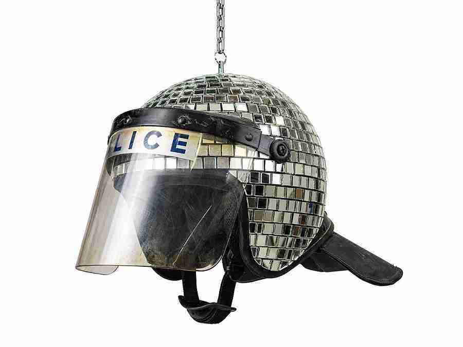 Met Ball, Banksy. Image of a riot police helmet covered in mirrors, like a disco ball of lights.