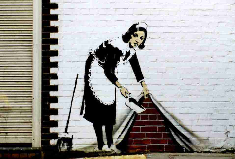 Sweep it under the carpet. A work by Banksy depicting a housekeeper hiding dirt behind a curtain.