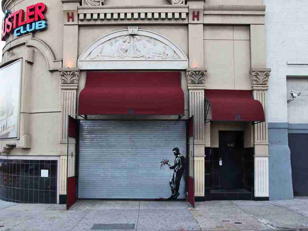 Waiting in vain, Banksy. Work made about the closing of a club in New York. It shows a man leaning on waiting with a bouquet of flowers.