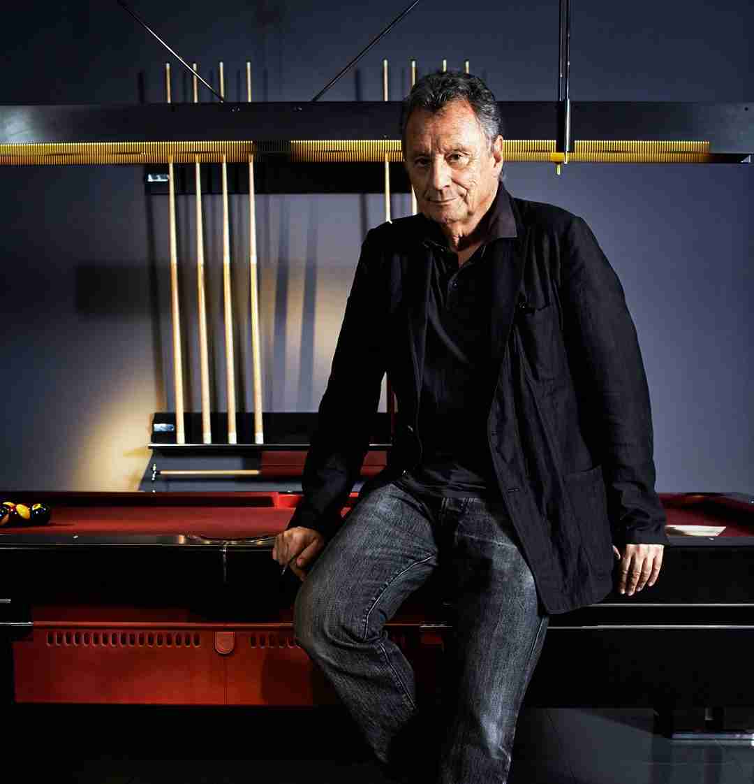Image of Jaime Tresserra leaning on the Bolero pool table. Behind the lamp and the dowel holder.
