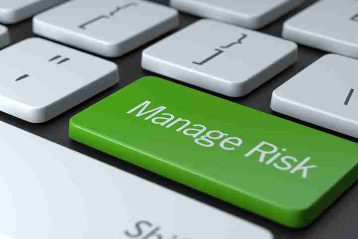 Imagen de un teclado de laptop con una tecla con el nombre "Manage Risk" (gestión del riesgo) sobre fondo verde.