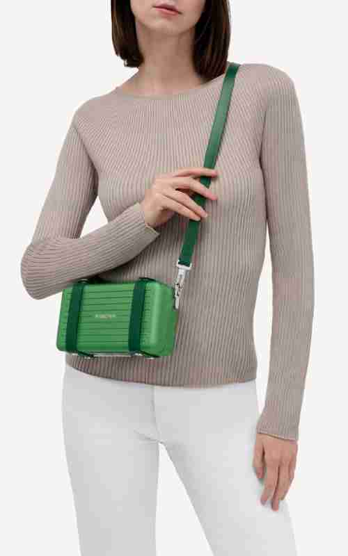 rimowa-bolso-bandolera-verde-emerald-500x800px.jpg Rimowa, aluminum shoulder bag in emerald green. Image of a young lady with a crossbody bag.