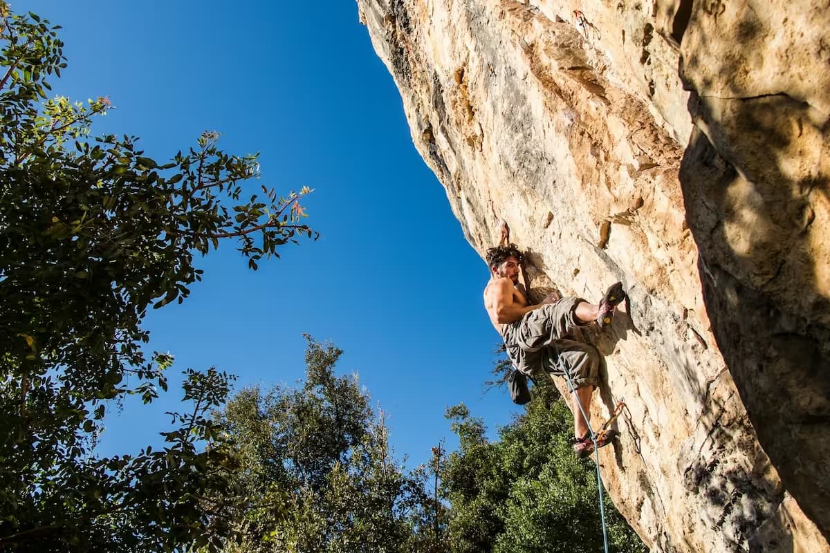 Desafío. Escalador comenzando una escalada vertical.