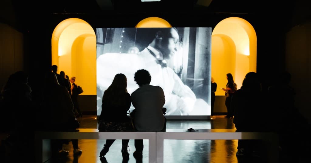 photo-london-1024x536px.jpg Photo london 2025. Image of two people viewing an image projection with photographs from Photo London.